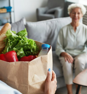 a person delivering groceries to an elderly woman